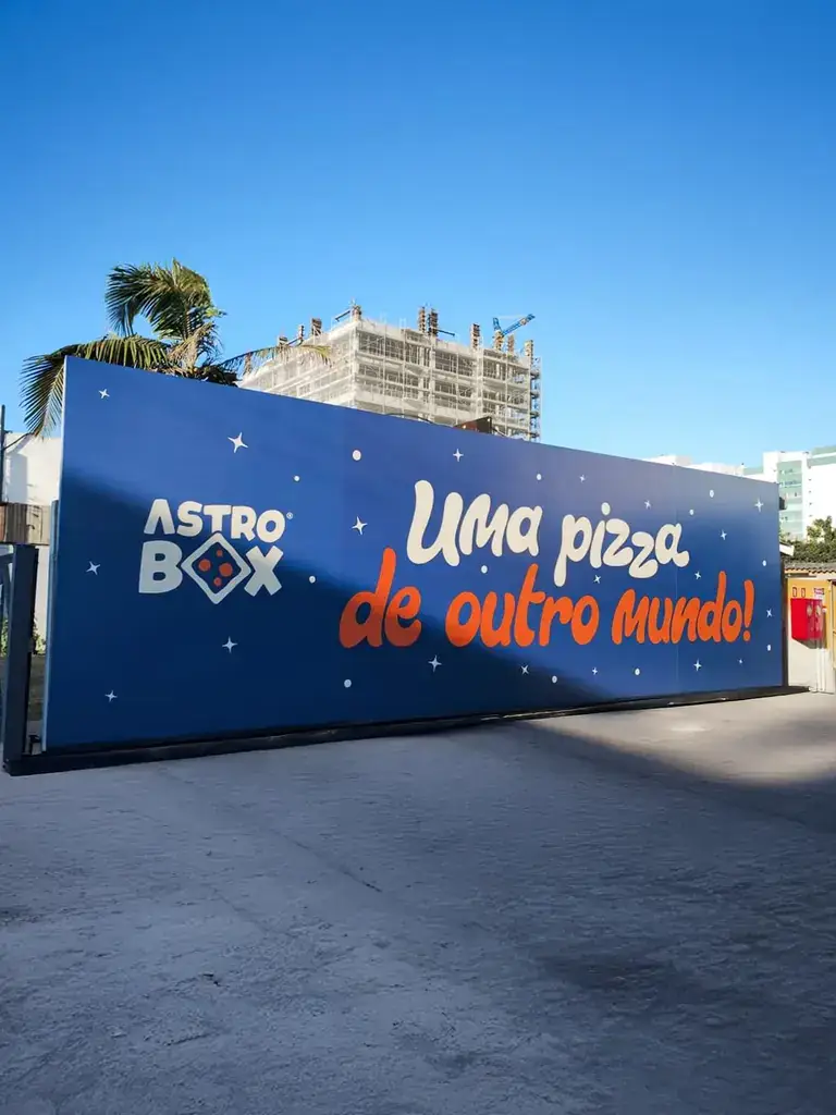 Tapume adesivado de grande formato da Astro Box com a frase Uma pizza de outro mundo